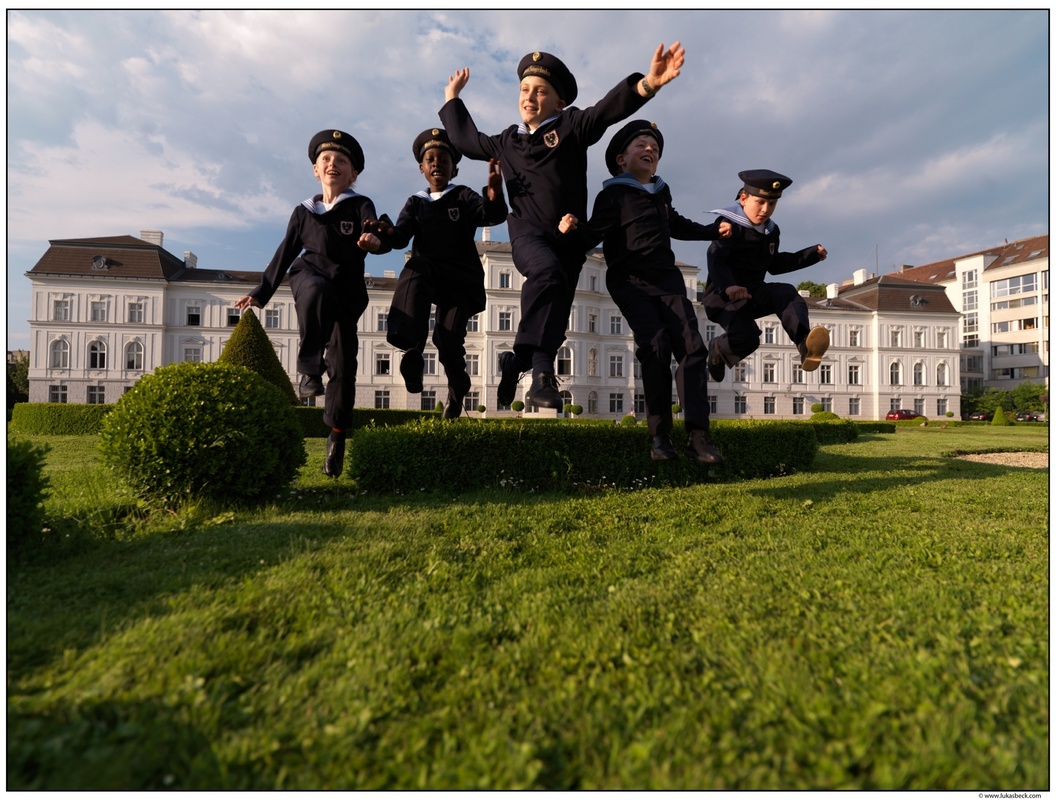 Sängerknaben springen vor dem Palais Augarten