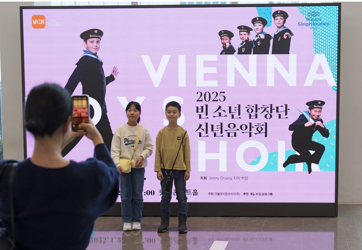 Kinder vor einem Konzertplakat der Wiener Sängerknaben in Korea
